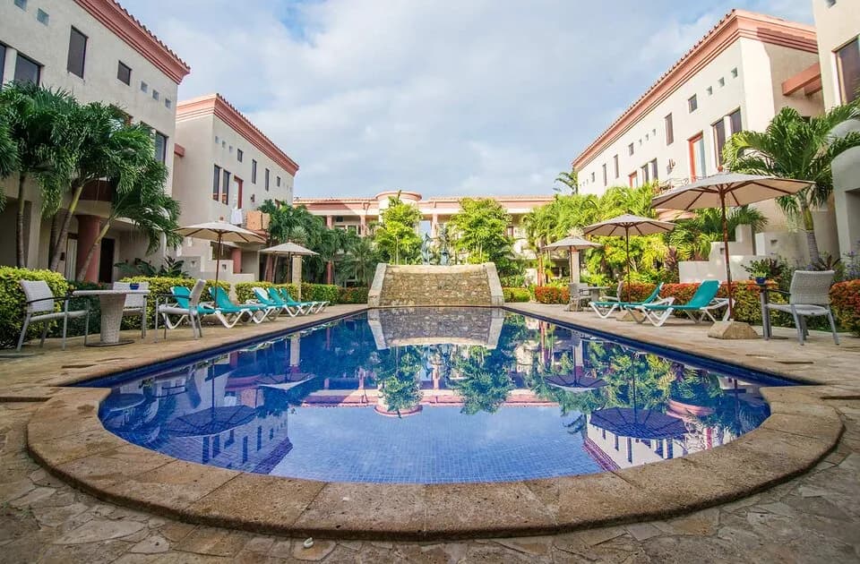 A pool in the middle of buildings at Las Sirenas by Mayan Princess Roatan