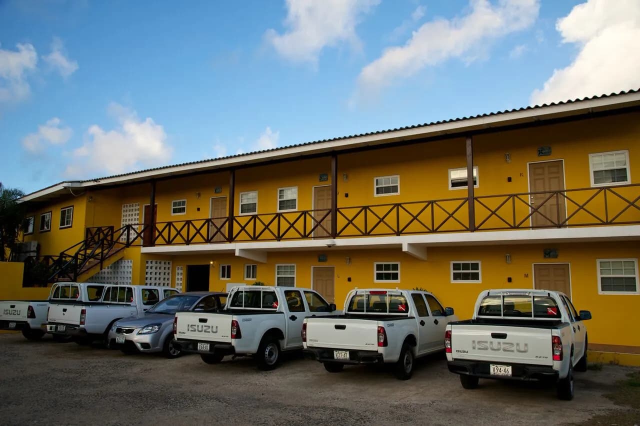 A row of parked trucks in front of a yellow building.